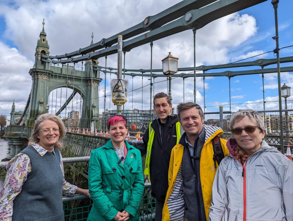 Zoe Garbett standing in front of Hammersmith Bridge with campaigners.